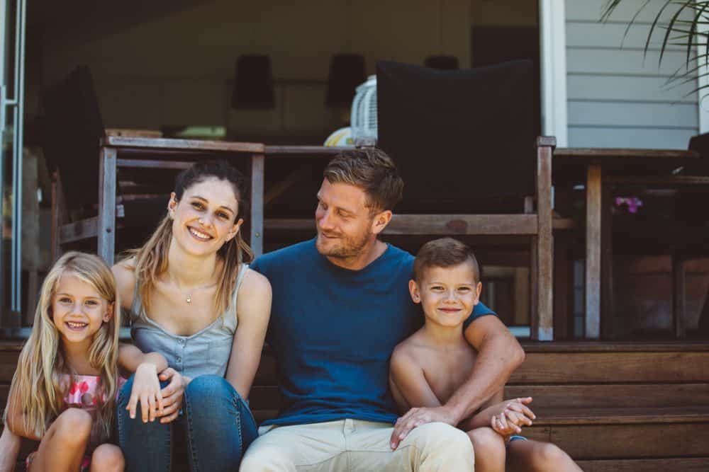 Casual family portrait on the steps of their backyard.