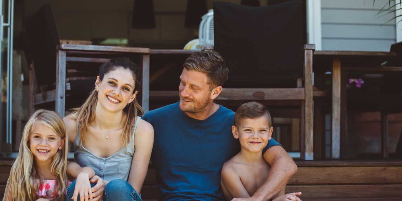 Casual family portrait on the steps of their backyard.