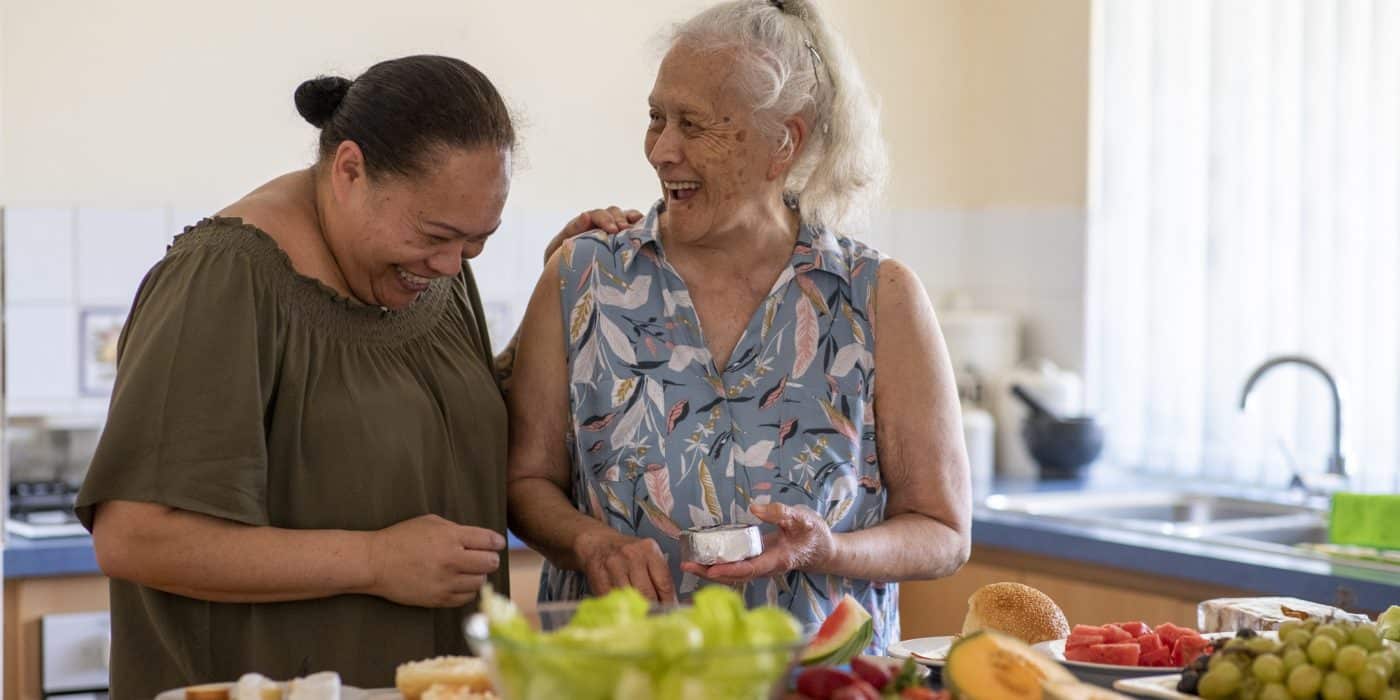 Senior Pacific Islander woman and her mature daughter preparing food together in their kitchen at home.