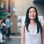 Portrait of a middle aged Japanese woman standing outdoors with arms crossed