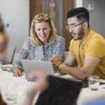 Mature businesswoman smiling with employee, working together, collaboration, teamwork