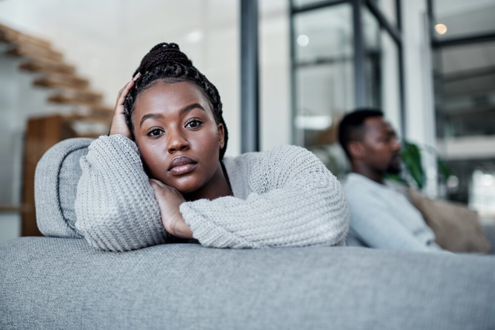 Shot of a young couple ignoring each other after having an argument on the sofa at home