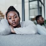 Shot of a young couple ignoring each other after having an argument on the sofa at home